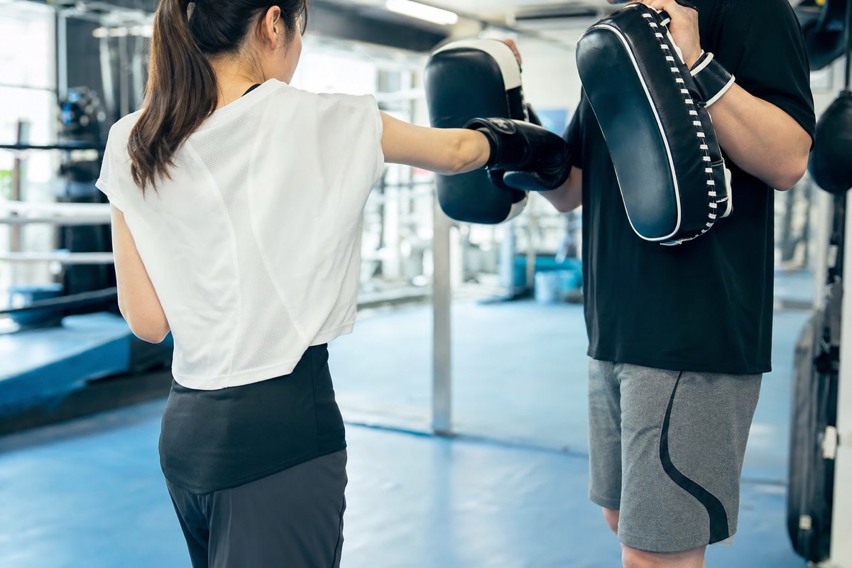 初心者向けのミットトレーニングを行う格闘技ジムの様子